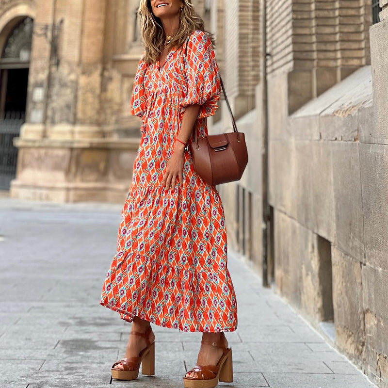 A woman in a summer bohemian v-neck dress stands by green doors, showcasing a flowy silhouette and boho-inspired design.