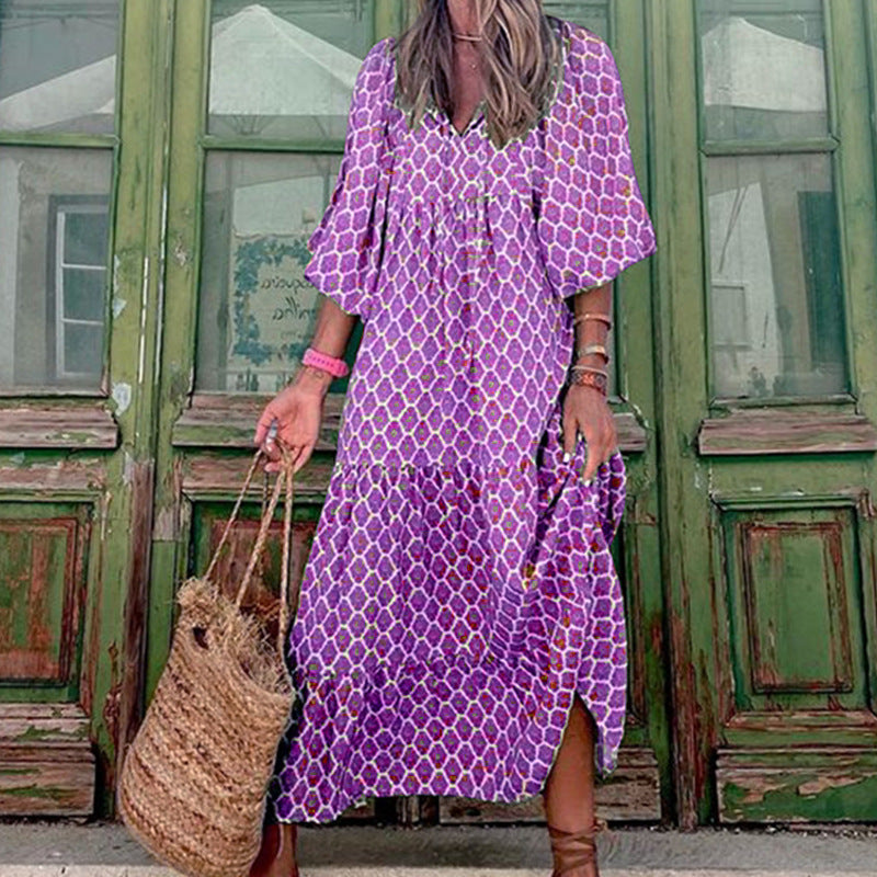 A woman in a summer bohemian v-neck dress stands by green doors, showcasing a flowy silhouette and boho-inspired design.