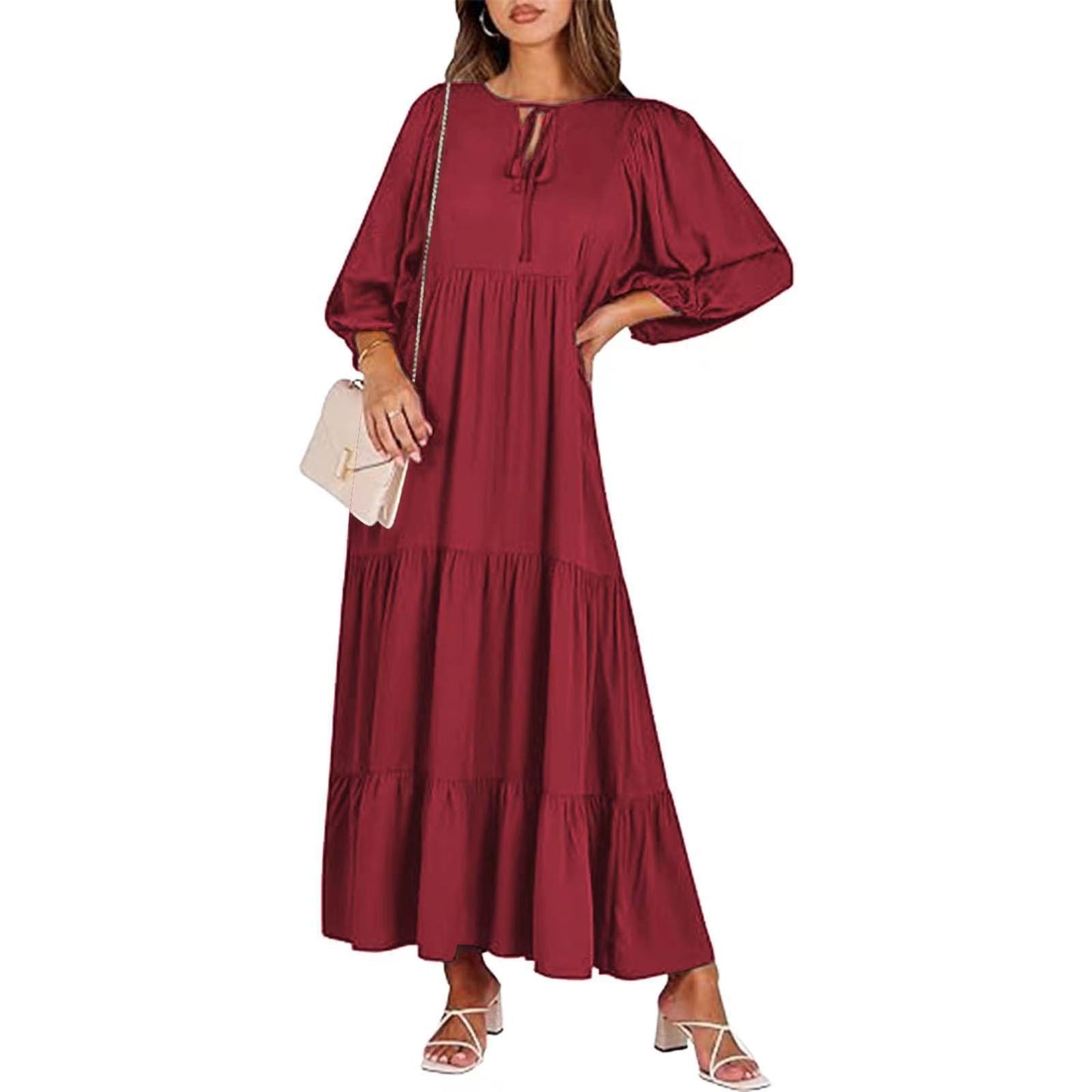 A woman in a summer bohemian v-neck dress stands by green doors, showcasing a flowy silhouette and boho-inspired design.