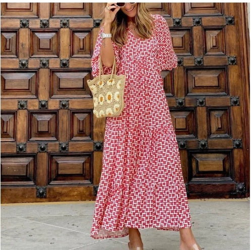 A woman in a summer bohemian v-neck dress stands by green doors, showcasing a flowy silhouette and boho-inspired design.