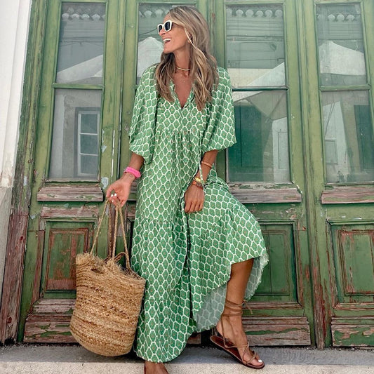 A woman in a summer bohemian v-neck dress stands by green doors, showcasing a flowy silhouette and boho-inspired design.